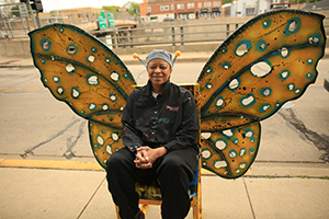 Photo of artist Tia Etu’s with her piece titled Butterfly at 840 S. Oak Park Ave.
