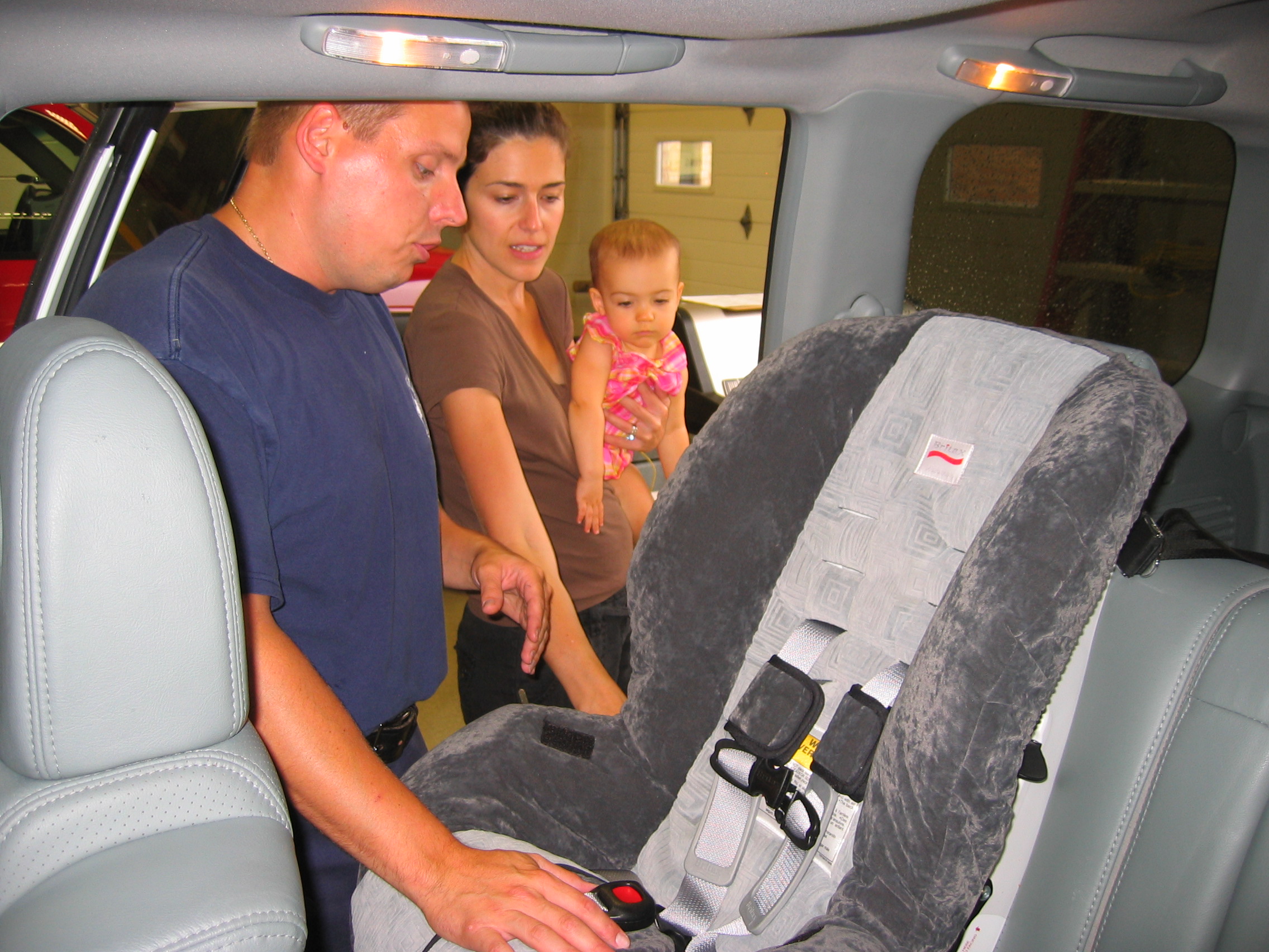 Firefighter/paramedic Michael Henkelman installs a child safety seat.